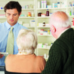 Pharmacist in pharmacy with senior couple