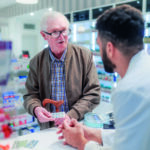 Young pharmacist explaining to customer how to dosing medication.