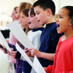 Group Of School Children Singing In Choir Together